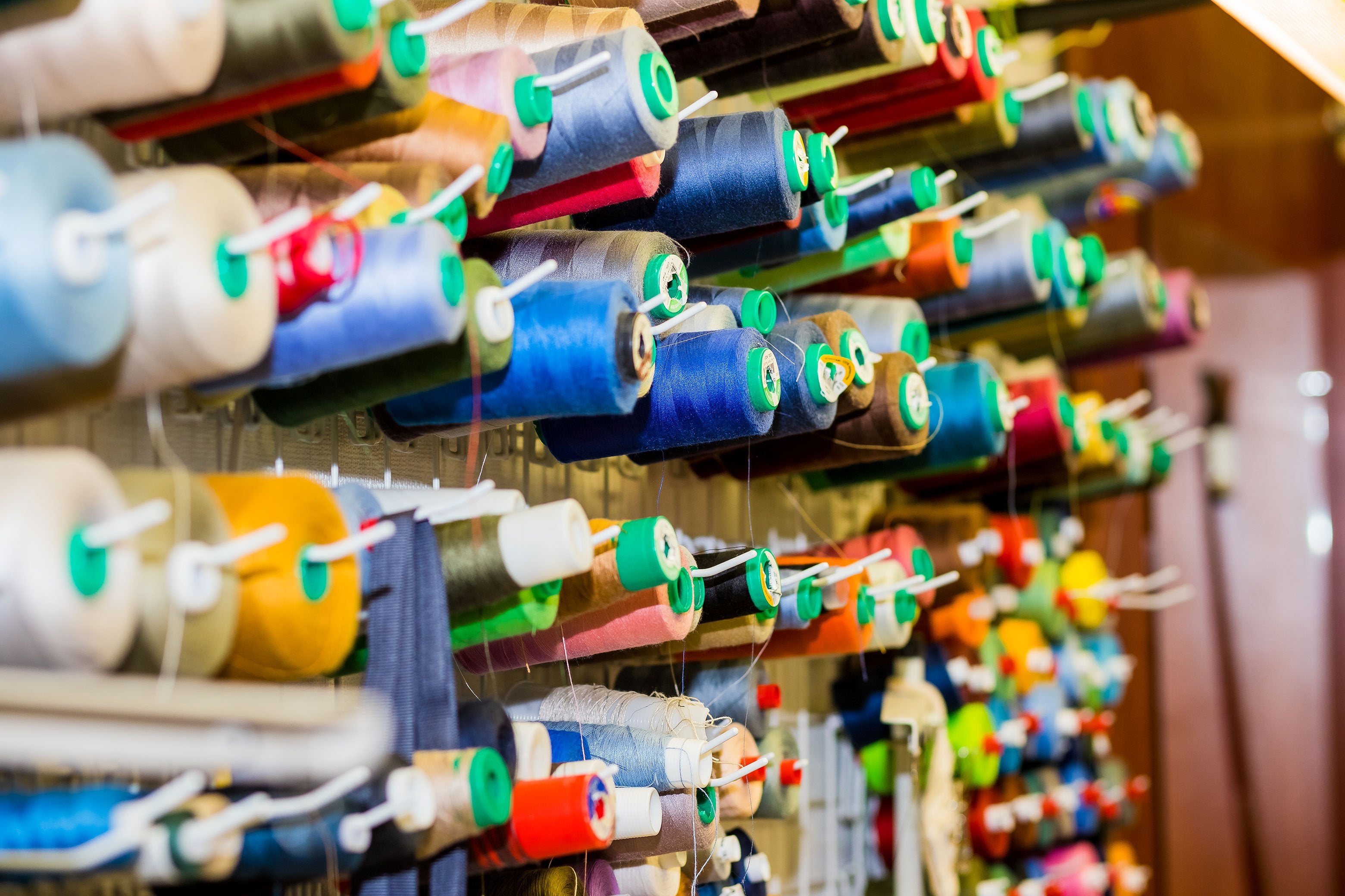 rolls of thread hanging on the factory wall